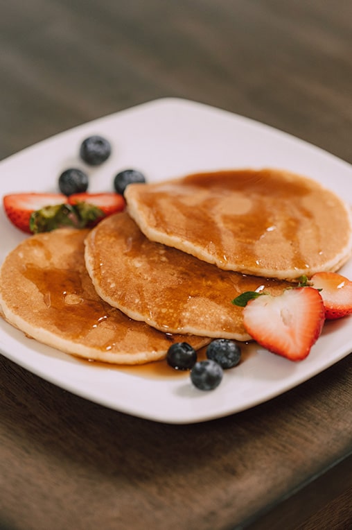 A picture of some pancakes and fruit. Brunch is another reason why Uluwatu is worth visiting. 