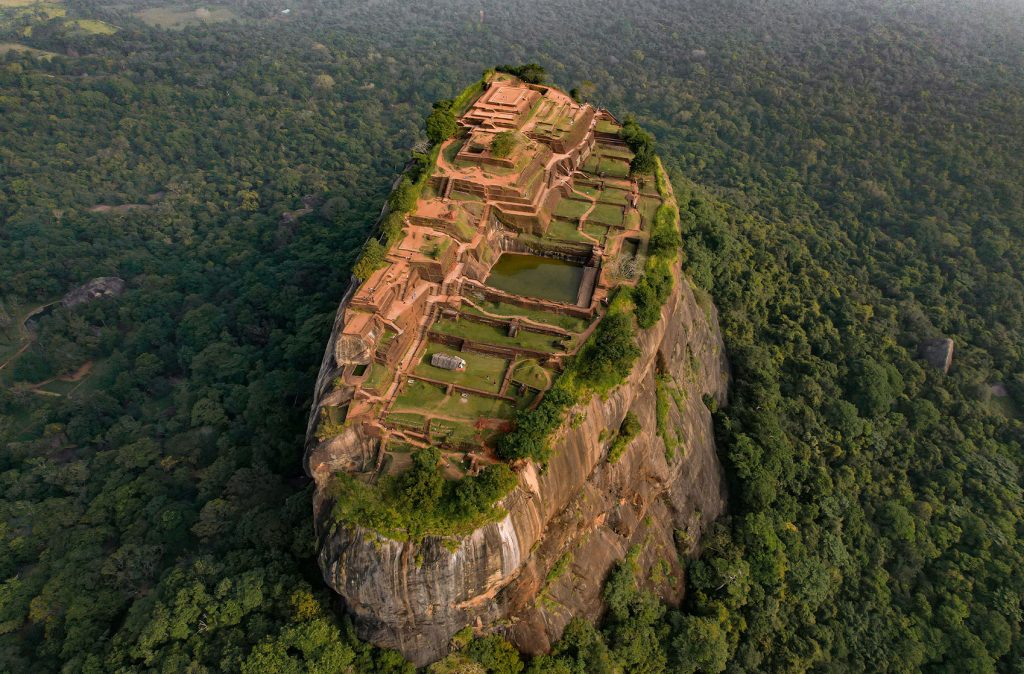 Aerial view of an ancient rock fortress with terraced gardens, a marvel of historical landscape architecture.