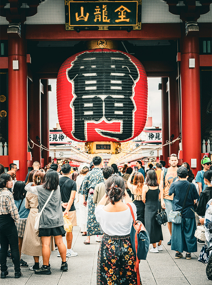 A crowd gathers at Kaminarimon Gate with its giant red lantern at Sensō-ji Temple in Tokyo.