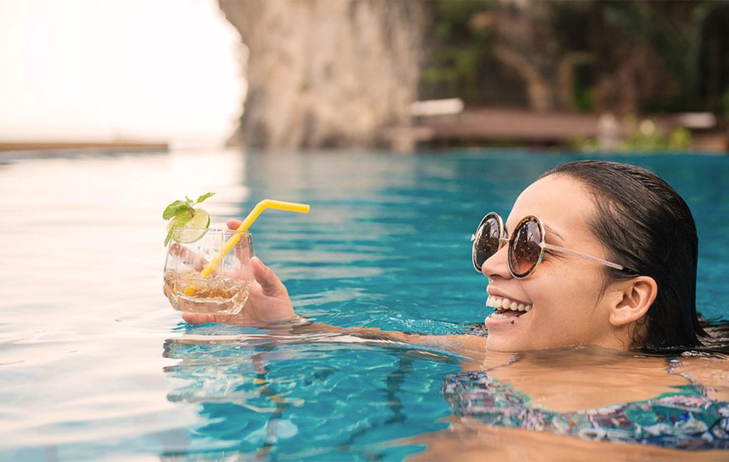 A woman with a drink in a pool in Thailand