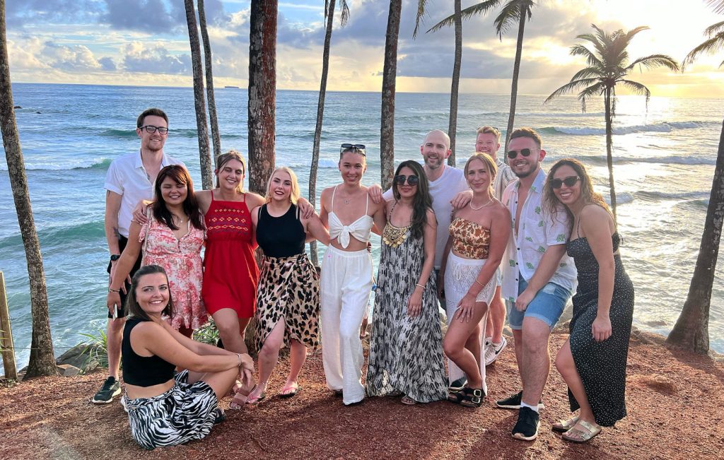 A group of friends posing together on Coconut Tree Hill in Mirissa at sunset.

