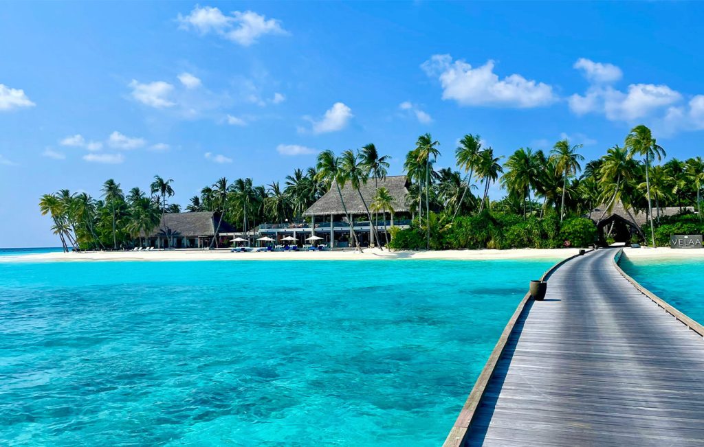 A tropical island resort in the Maldives surrounded by turquoise waters and white sand.

