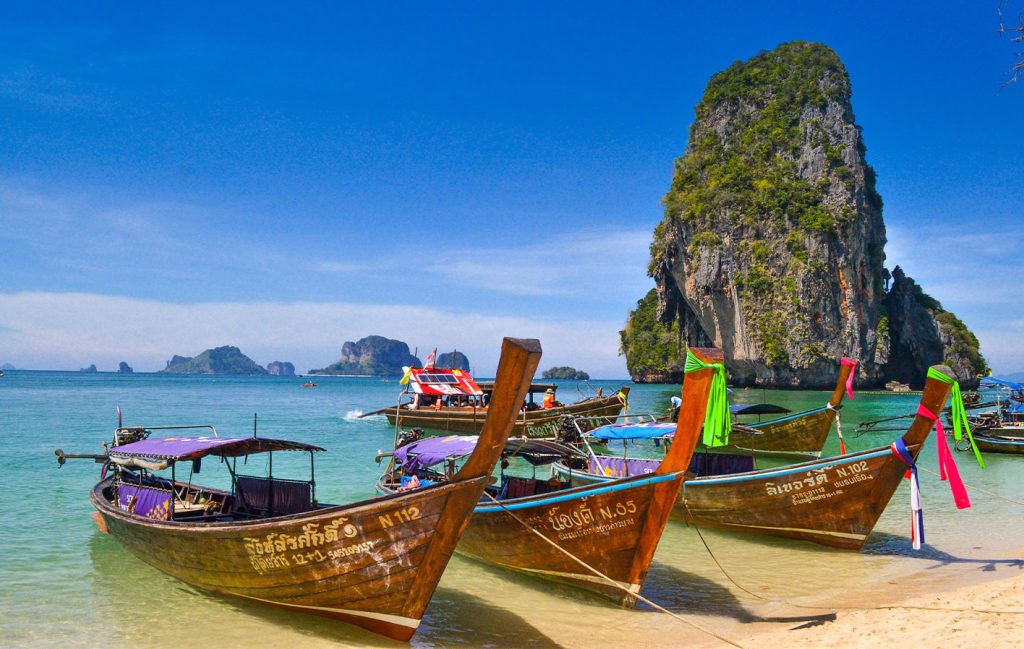 A photo of long tailed boats on a beach in Thailand