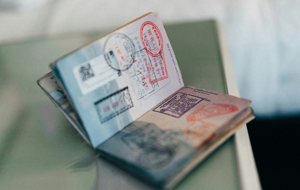 An open passport displays colorful stamps from various countries.