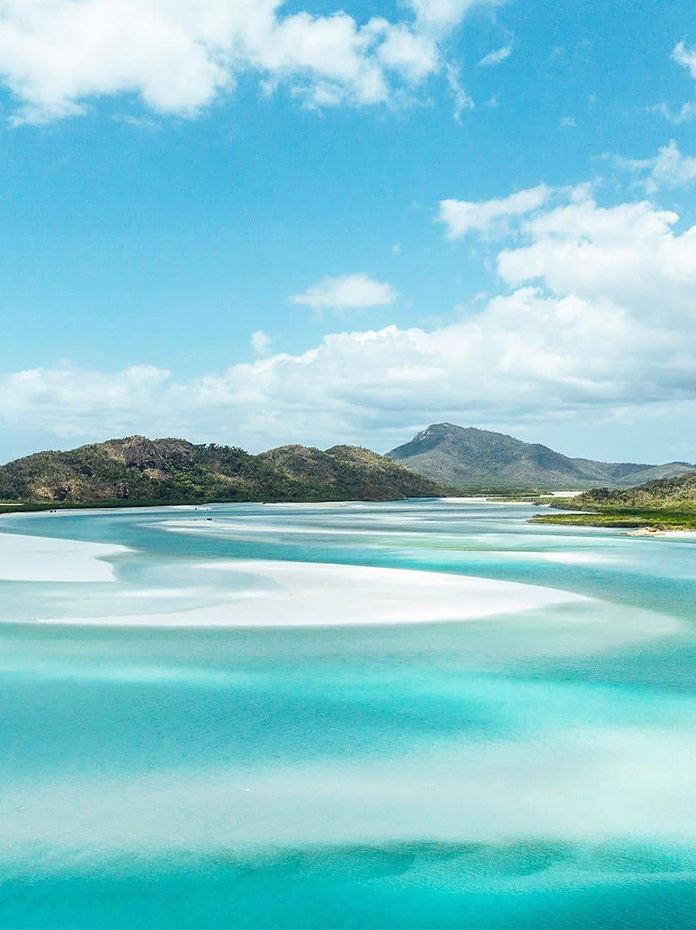 A stunning view of turquoise waters and white sands blending at Whitehaven Beach.