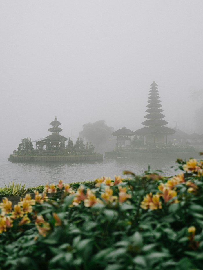 A misty morning view of Ulun Danu Beratan Temple by the lake, partly hidden in fog.