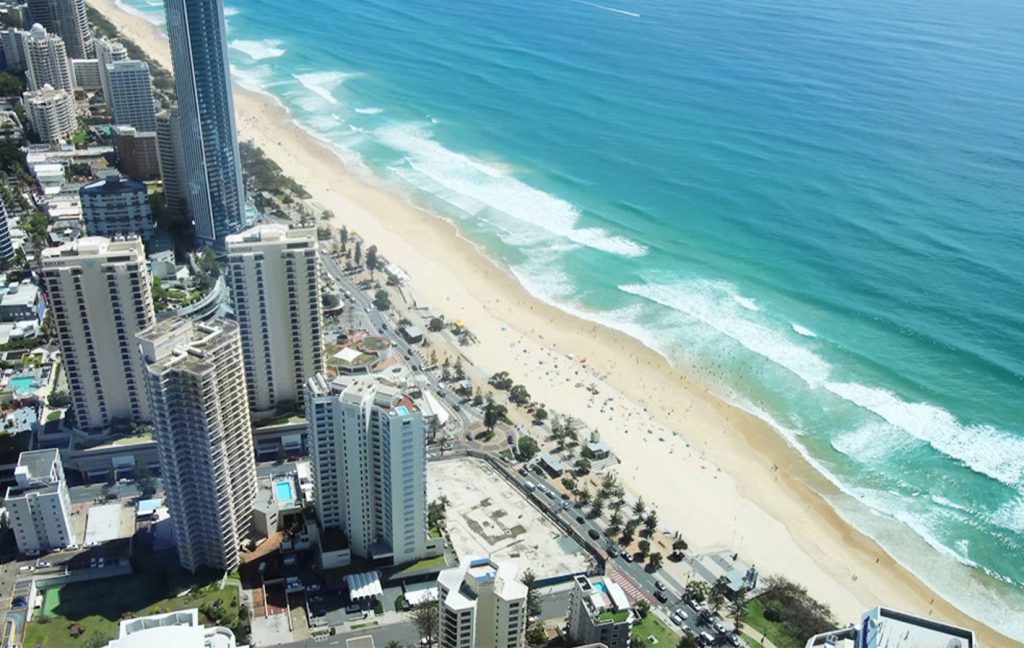 Aerial view of Gold Coast’s golden beaches lined with tall skyscrapers.